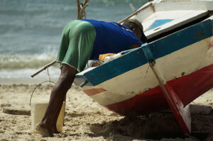 Un homme lave un bateau sur l'île d'Itaparica