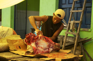 Un homme découpe une tête de bœeuf sur le marché de Mucugé